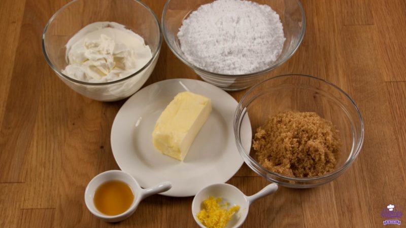 Brown sugar cream cheese frosting ingredients photographed from above on a wooden surface.